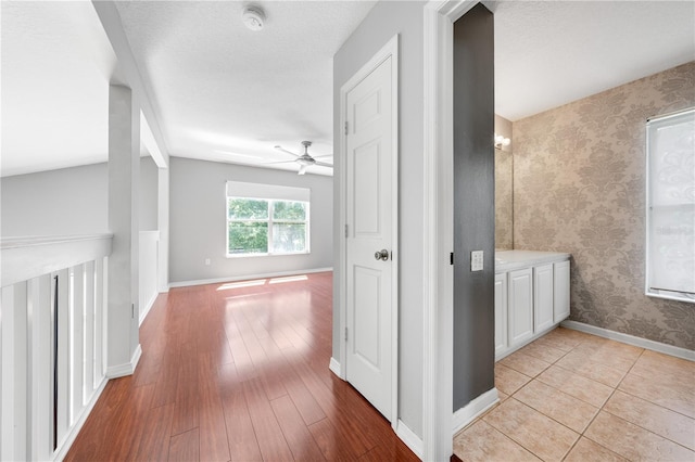 3203 Herons Point Cir, Kissimmee, FL 34741 - hallway with baseboards, light wood-style floors, and wallpapered walls