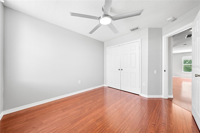 3203 Herons Point Cir, Kissimmee, FL 34741 - unfurnished bedroom with wood finished floors, a closet, baseboards, a textured ceiling, and a ceiling fan