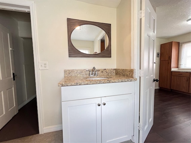 1413 11th St, Saint Cloud, FL 34769 - bathroom with vanity, a textured ceiling, baseboards, and wood finished floors