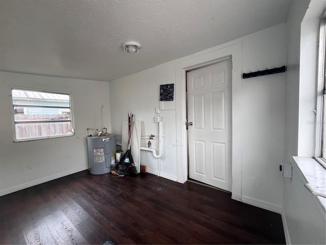 1413 11th St, Saint Cloud, FL 34769 - foyer entrance with water heater, wood finished floors, baseboards, and a textured ceiling