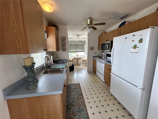 1410 Sanchez Ct, Lady Lake, FL 32159 - kitchen with white appliances, a sink, light flooring, a ceiling fan, and a textured ceiling