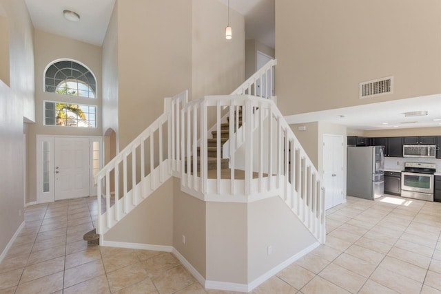 12303 Bohannon Blvd, Orlando, FL 32824 - stairs featuring a towering ceiling, tile patterned floors, and baseboards