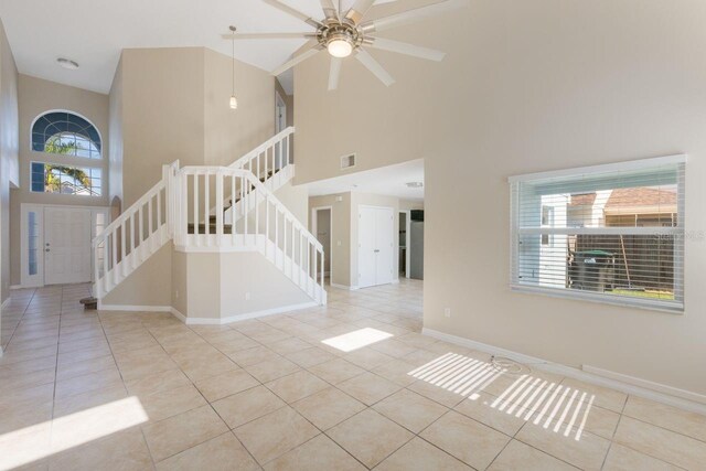 12303 Bohannon Blvd, Orlando, FL 32824 - unfurnished living room featuring high vaulted ceiling, tile patterned floors, stairway, a ceiling fan, and baseboards