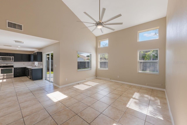 12303 Bohannon Blvd, Orlando, FL 32824 - unfurnished living room with high vaulted ceiling, light tile patterned flooring, ceiling fan, and baseboards