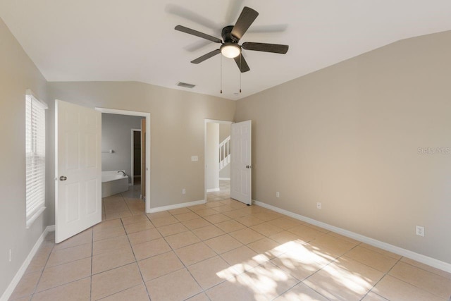12303 Bohannon Blvd, Orlando, FL 32824 - unfurnished bedroom with light tile patterned floors, lofted ceiling, baseboards, and a ceiling fan