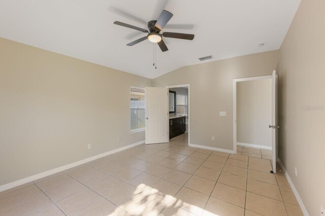 12303 Bohannon Blvd, Orlando, FL 32824 - unfurnished bedroom featuring lofted ceiling, light tile patterned flooring, baseboards, and ceiling fan