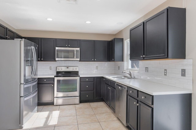 12303 Bohannon Blvd, Orlando, FL 32824 - kitchen with appliances with stainless steel finishes, a sink, light tile patterned floors, backsplash, and light countertops