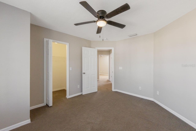 12303 Bohannon Blvd, Orlando, FL 32824 - unfurnished bedroom featuring a spacious closet, baseboards, carpet floors, a ceiling fan, and a closet