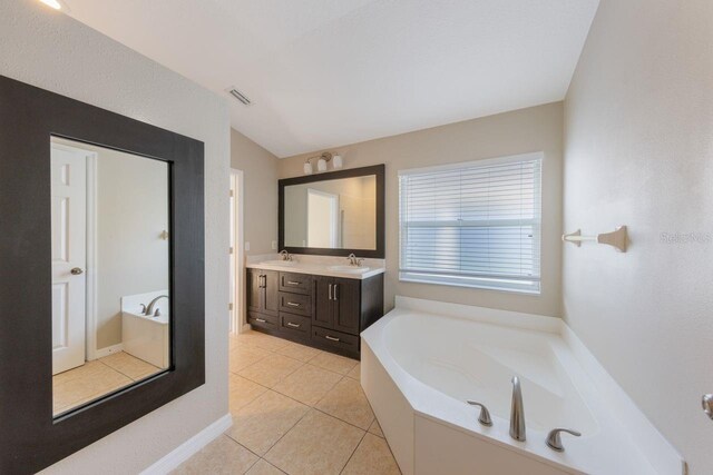 12303 Bohannon Blvd, Orlando, FL 32824 - bathroom with a garden tub, double vanity, tile patterned floors, and vaulted ceiling