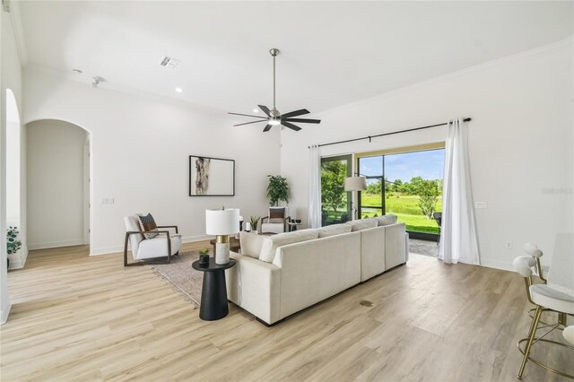 517 Milano Rd, Poinciana, FL 34759 - living area featuring arched walkways, a ceiling fan, light wood finished floors, ornamental molding, and baseboards