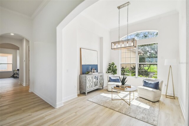 517 Milano Rd, Poinciana, FL 34759 - sitting room featuring arched walkways, ornamental molding, healthy amount of natural light, and wood finished floors