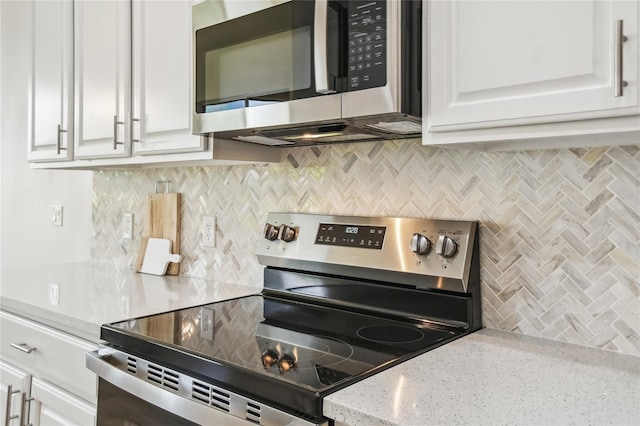 517 Milano Rd, Poinciana, FL 34759 - kitchen featuring stainless steel appliances, backsplash, white cabinetry, and light stone counters