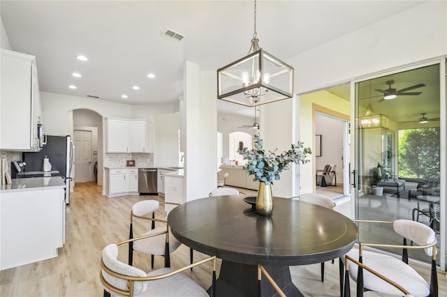 517 Milano Rd, Poinciana, FL 34759 - dining area with a ceiling fan, arched walkways, light wood-style flooring, recessed lighting, and a chandelier