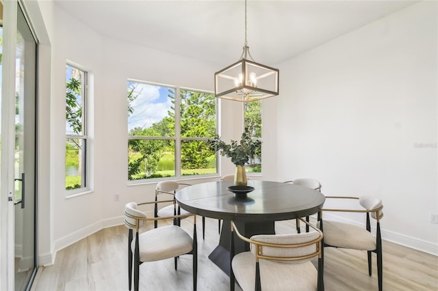 517 Milano Rd, Poinciana, FL 34759 - dining space featuring a chandelier, light wood-style flooring, and baseboards