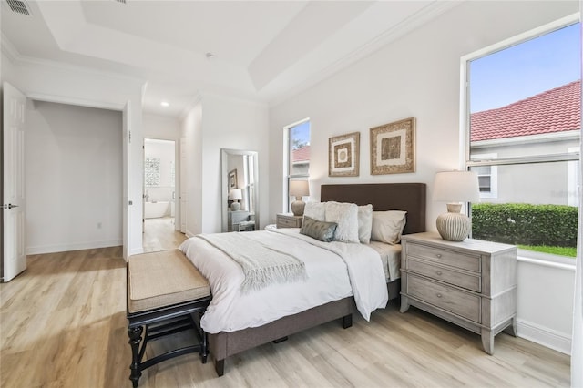 517 Milano Rd, Poinciana, FL 34759 - bedroom with light wood-style flooring, baseboards, a tray ceiling, ornamental molding, and connected bathroom