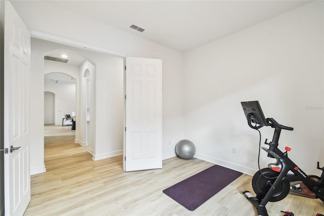 517 Milano Rd, Poinciana, FL 34759 - exercise area with arched walkways, light wood-type flooring, and baseboards