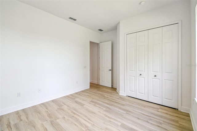 517 Milano Rd, Poinciana, FL 34759 - unfurnished bedroom featuring light wood finished floors, baseboards, and a closet
