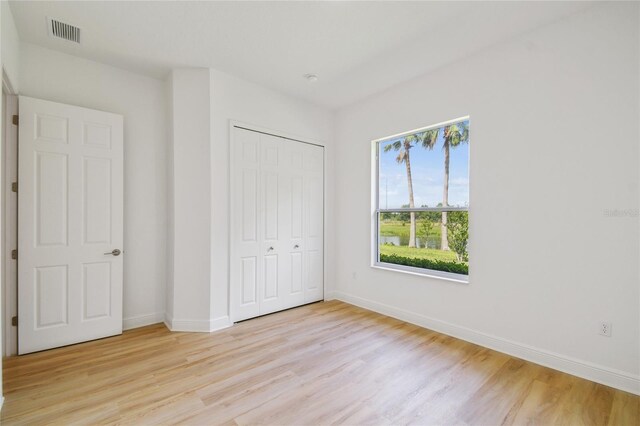 517 Milano Rd, Poinciana, FL 34759 - unfurnished bedroom with light wood finished floors, a closet, and baseboards
