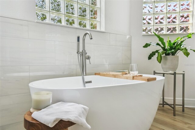 517 Milano Rd, Poinciana, FL 34759 - bathroom with a sink, a soaking tub, and wood finished floors