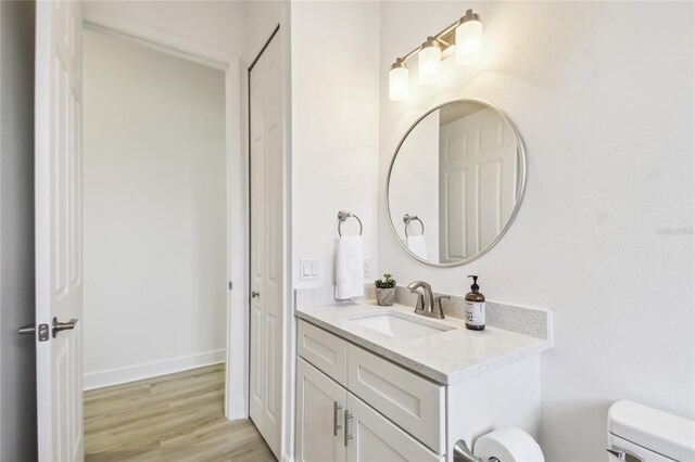 517 Milano Rd, Poinciana, FL 34759 - bathroom featuring toilet, vanity, wood finished floors, and baseboards