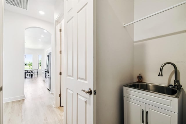517 Milano Rd, Poinciana, FL 34759 - clothes washing area with a sink, arched walkways, recessed lighting, and light wood-type flooring