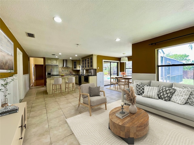 7200 Green Pine Ct, Orlando, FL 32819 - living area with a textured ceiling, a wainscoted wall, recessed lighting, and light tile patterned flooring