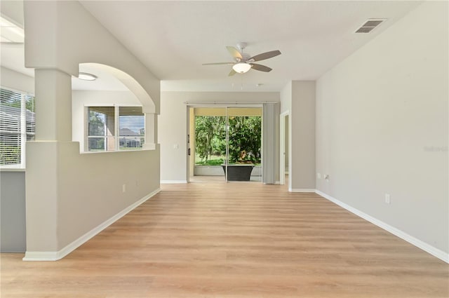 spare room with ceiling fan, light wood-style flooring, and baseboards