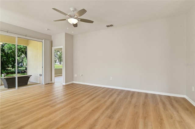 empty room with light wood-style flooring, a ceiling fan, and baseboards