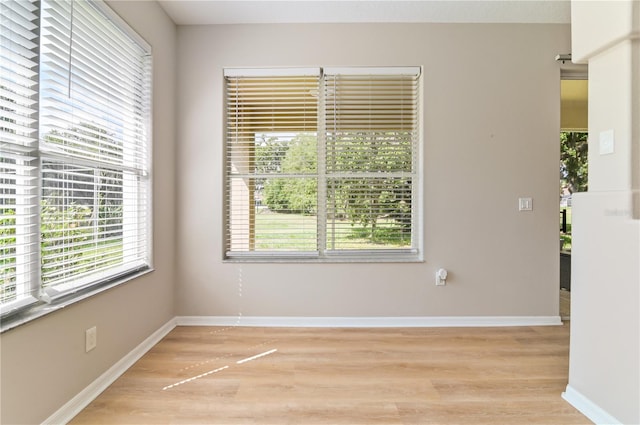 empty room with light wood-style flooring and baseboards
