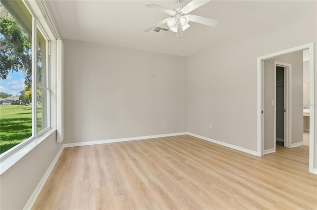 unfurnished room with light wood-style floors, a ceiling fan, and baseboards