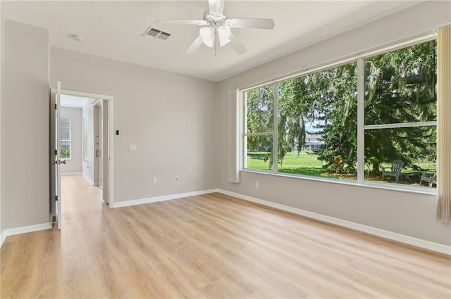 unfurnished room featuring light wood finished floors, a ceiling fan, baseboards, and a smoke detector