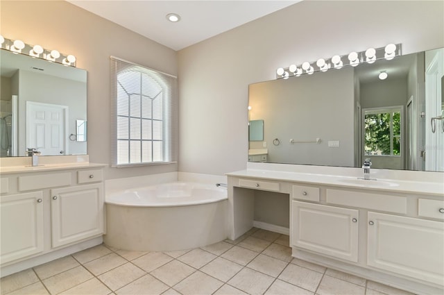 bathroom featuring a garden tub, tile patterned floors, and two vanities