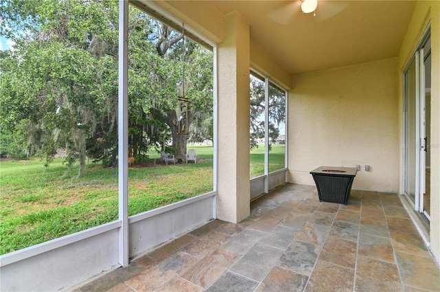 unfurnished sunroom with a ceiling fan
