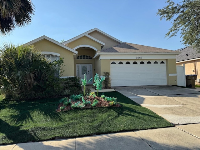 2567 Oneida Loop, Kissimmee, FL 34747 - ranch-style house with stucco siding, a garage, concrete driveway, and a front lawn