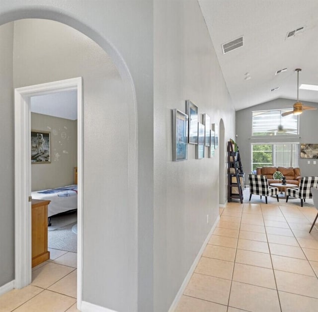 2567 Oneida Loop, Kissimmee, FL 34747 - corridor featuring light tile patterned floors, lofted ceiling, arched walkways, and baseboards