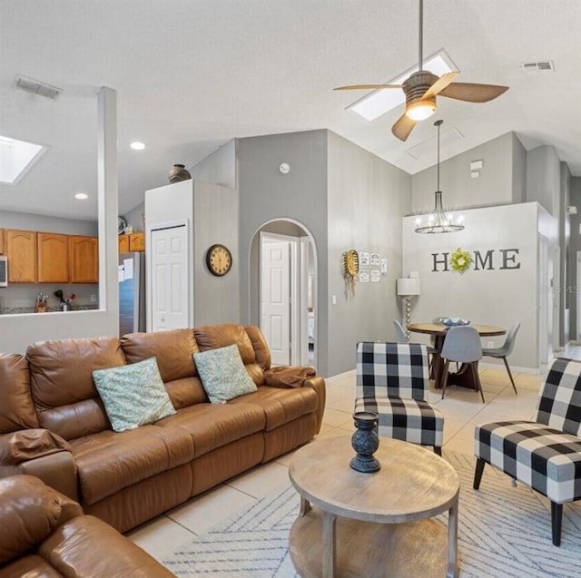 2567 Oneida Loop, Kissimmee, FL 34747 - living room featuring ceiling fan, arched walkways, light tile patterned floors, a chandelier, and a skylight