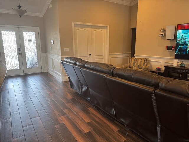 18805 Nettleton St, Orlando, FL 32833 - living area with crown molding, french doors, a wainscoted wall, dark wood-type flooring, and a decorative wall