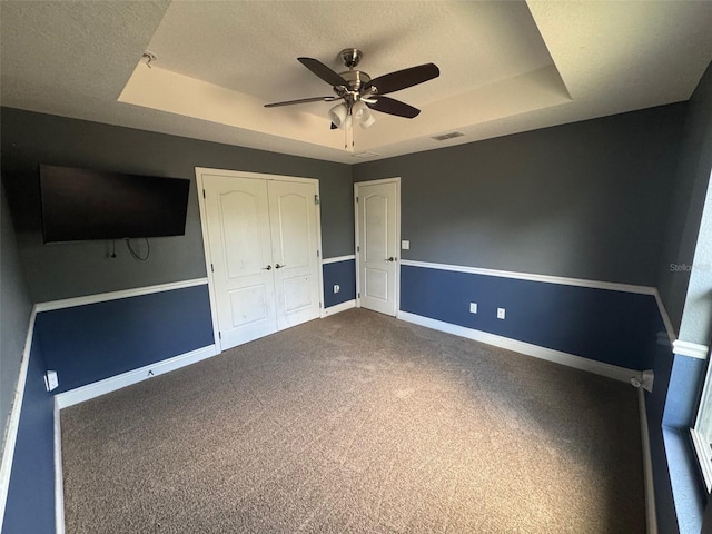 18805 Nettleton St, Orlando, FL 32833 - unfurnished bedroom with a raised ceiling, baseboards, dark colored carpet, a closet, and a ceiling fan