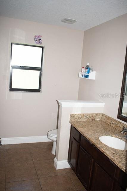 18805 Nettleton St, Orlando, FL 32833 - bathroom featuring vanity, tile patterned flooring, toilet, baseboards, and a textured ceiling