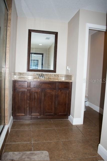 18805 Nettleton St, Orlando, FL 32833 - full bathroom featuring vanity, a shower stall, toilet, baseboards, and tile patterned flooring