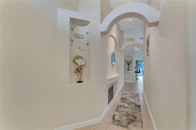 620 Old Bridge Cir, Davenport, FL 33897 - hall featuring arched walkways, a towering ceiling, light tile patterned floors, and baseboards