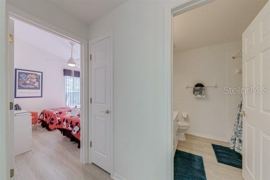 926 Balmoral Dr, Davenport, FL 33896 - bathroom with wood finished floors, ceiling fan, toilet, and curtained shower