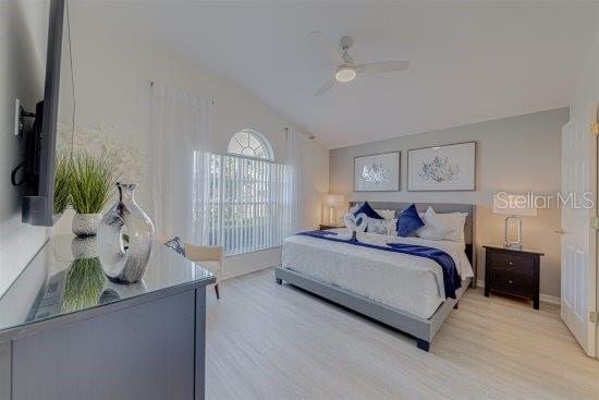 926 Balmoral Dr, Davenport, FL 33896 - bedroom featuring lofted ceiling, light wood-style flooring, ceiling fan, and baseboards