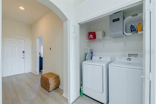 926 Balmoral Dr, Davenport, FL 33896 - laundry room with arched walkways, independent washer and dryer, wood finished floors, and baseboards