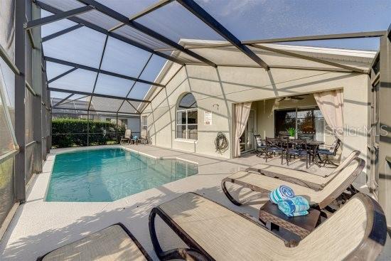 926 Balmoral Dr, Davenport, FL 33896 - swimming pool featuring a patio, outdoor dining space, and a lanai