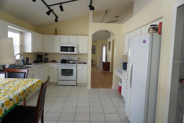 10308 Soaring Eagle Dr, Riverview, FL 33578 - kitchen with white appliances, a sink, track lighting, white cabinets, and vaulted ceiling