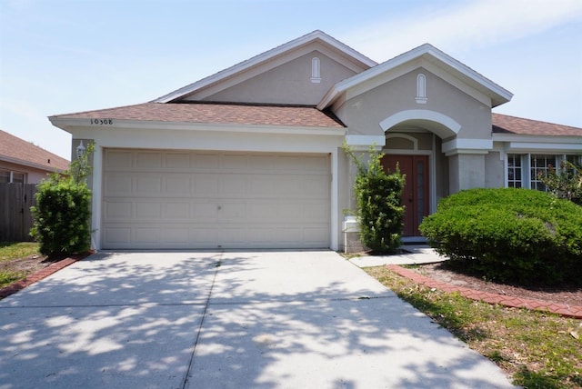 10308 Soaring Eagle Dr, Riverview, FL 33578 - view of front facade featuring stucco siding, driveway, roof with shingles, and an attached garage