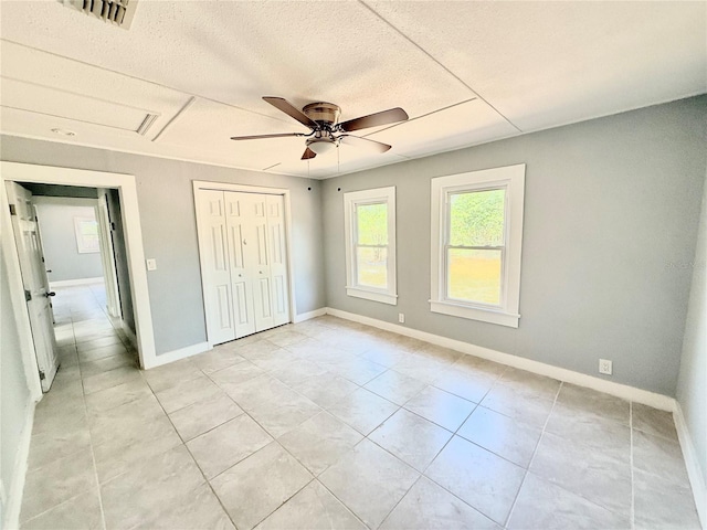 6100 Skokie Rd, Lake Wales, FL 33898 - unfurnished bedroom with light tile patterned flooring, a closet, baseboards, a ceiling fan, and a textured ceiling