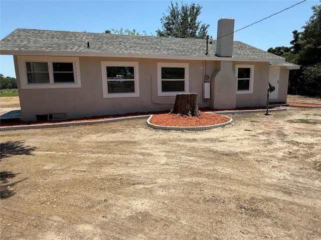 6100 Skokie Rd, Lake Wales, FL 33898 - rear view of house featuring roof with shingles, stucco siding, and a chimney