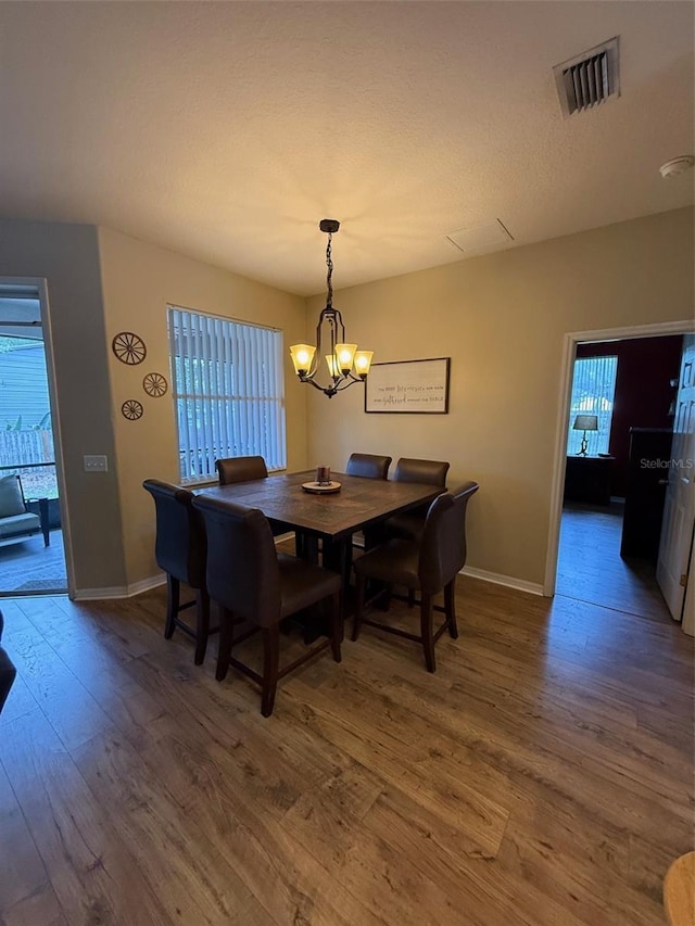 dining space with wood finished floors, plenty of natural light, and baseboards